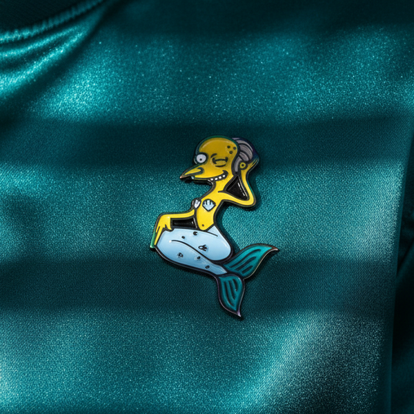 Mermaid Mr. Burns enamel pin with yellow character, pale blue tail, and teal fins