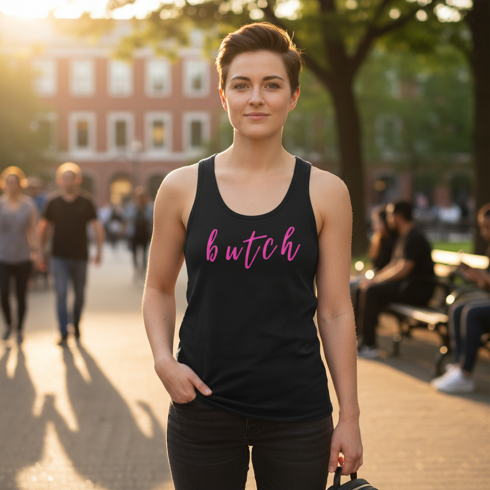 Butch Unisex Tank Top in black, “butch” across the chest in pink script, worn by a short-haired queer person in a sunny park.