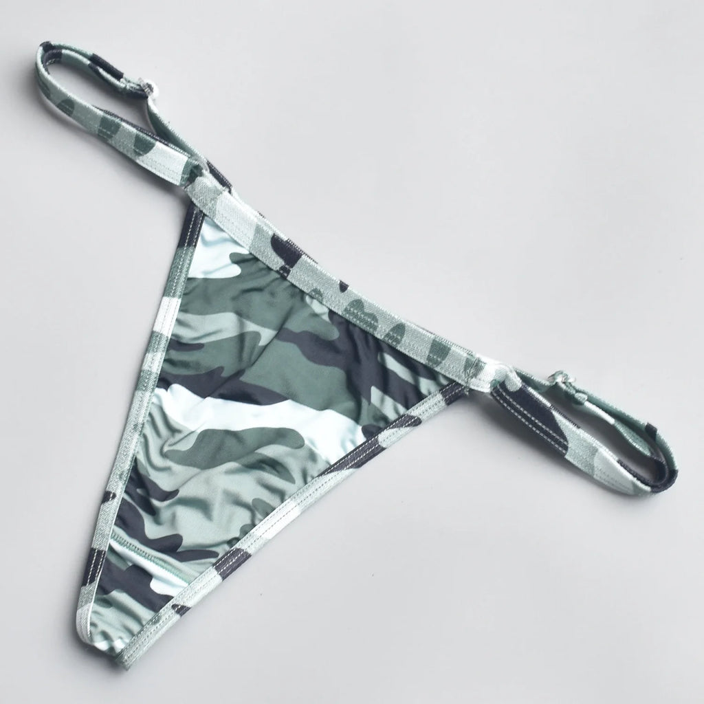 Camo-print thong with narrow matching straps, laid flat on a white background