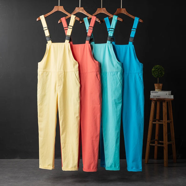 Four colorful adjustable overalls hang side by side: pale yellow, coral, aqua, and bright blue.