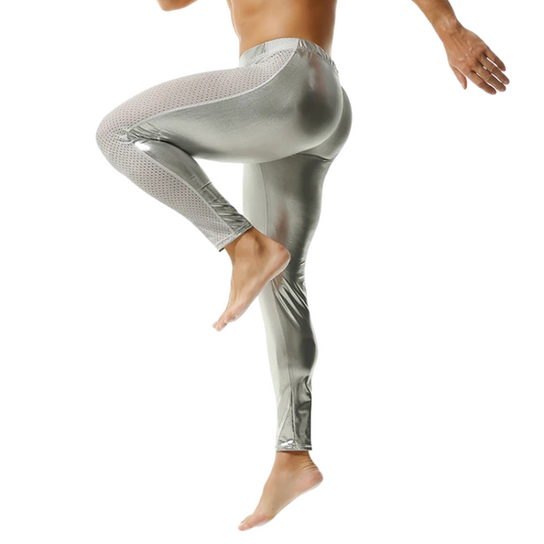 Rear view of a model wearing shiny silver PU leggings with one leg raised
