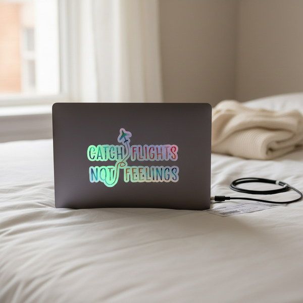 Laptop with “Catch Flights Not Feelings” holographic sticker sits on a tidy bed; black charger, cream knit blanket