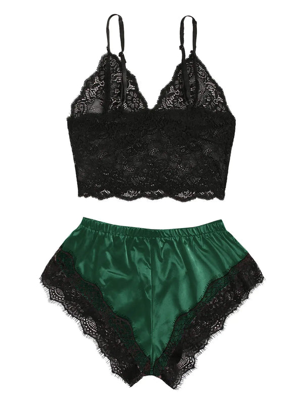 Flat lay of a black lace camisole and emerald green satin shorts with black lace trim