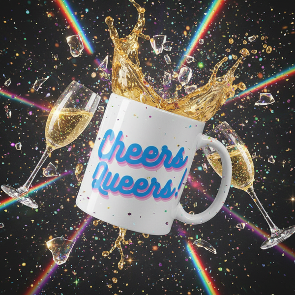 White Cheers Queers mug amid champagne glasses, confetti, gold splashes, and rainbow beams