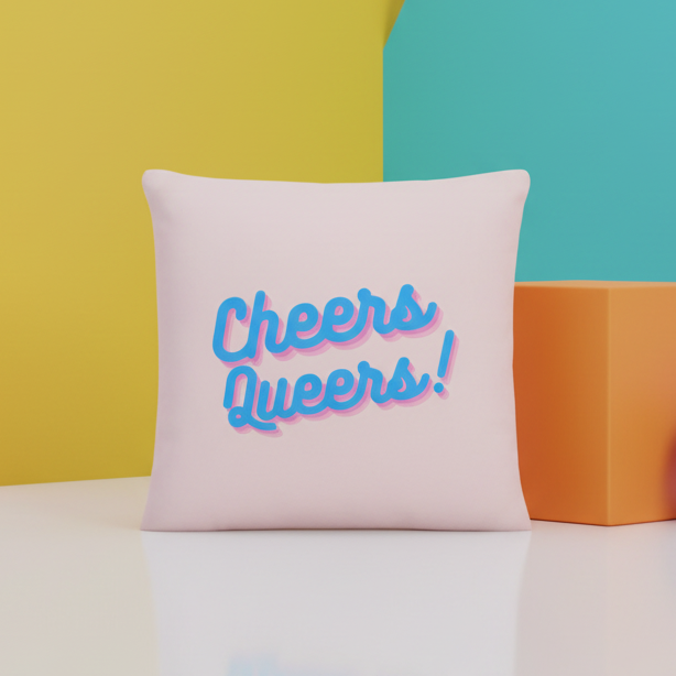 Light pink "Cheers Queers!" pillow with bold text and vibrant yellow, turquoise