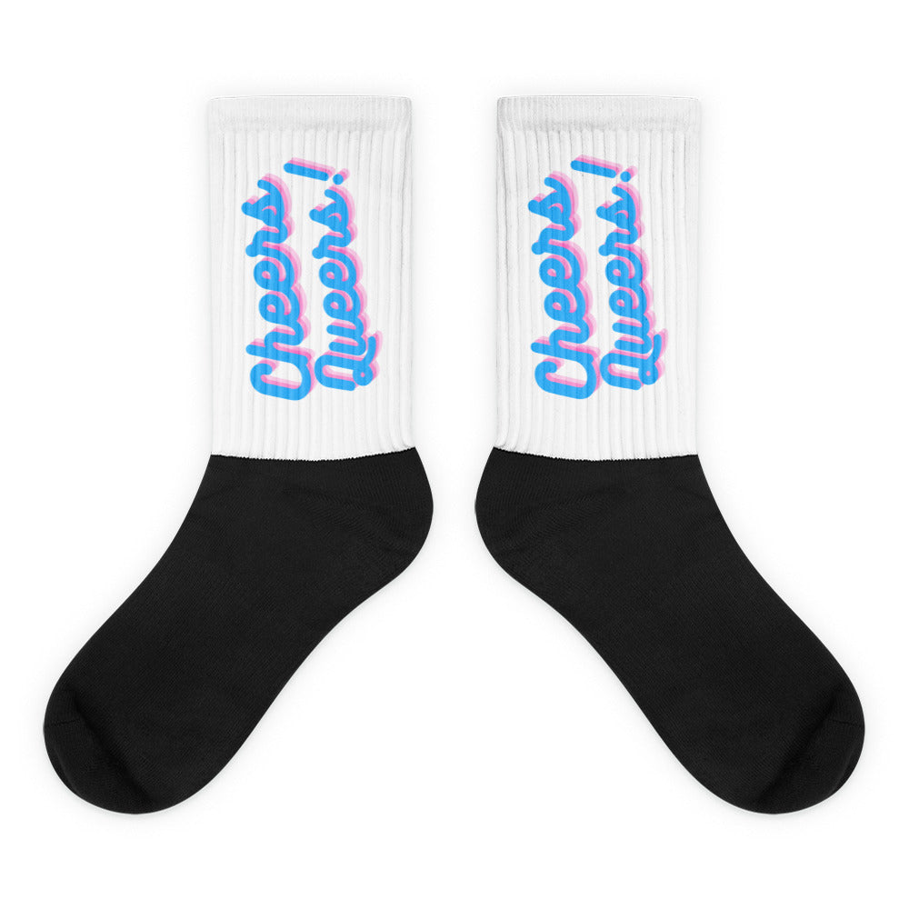Pair of black-and-white socks with pink-and-blue “Cheers Queers!” cuffs