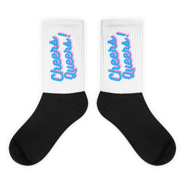 Pair of black-and-white socks with pink-and-blue “Cheers Queers!” cuffs