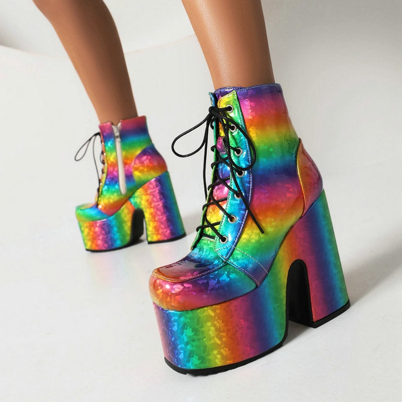 Pair of rainbow holographic platform ankle boots with black laces, shown from the front right