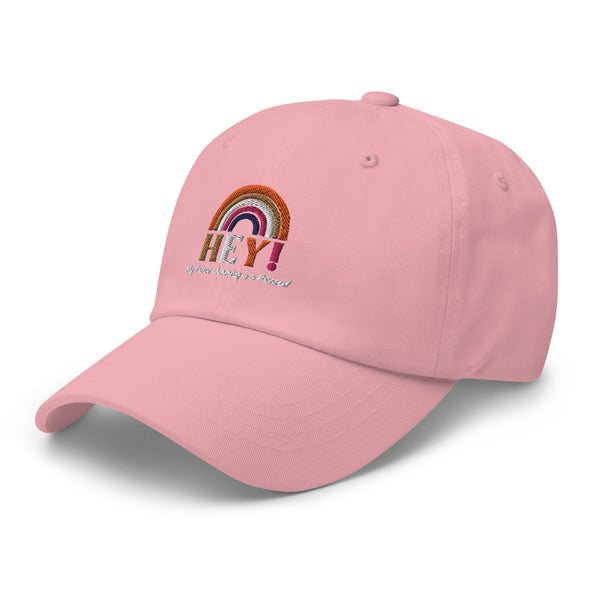 White dad hat with a curved brim, embroidered boho rainbow, and colorful “HEY! My Prince Charming is a Princess” queer slogan.