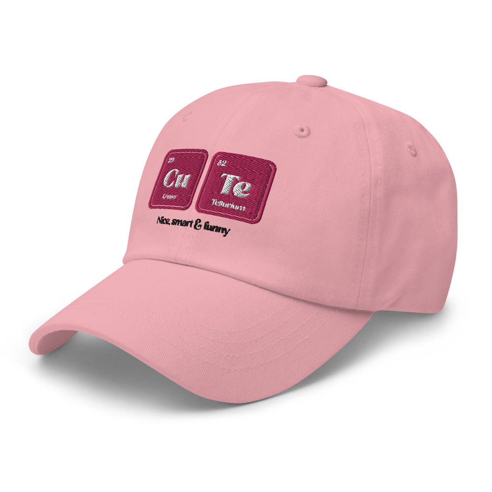 Light pink dad hat with "Cu" and "Te" embroidered like periodic table blocks, plus “nice, smart & funny” in black script.
