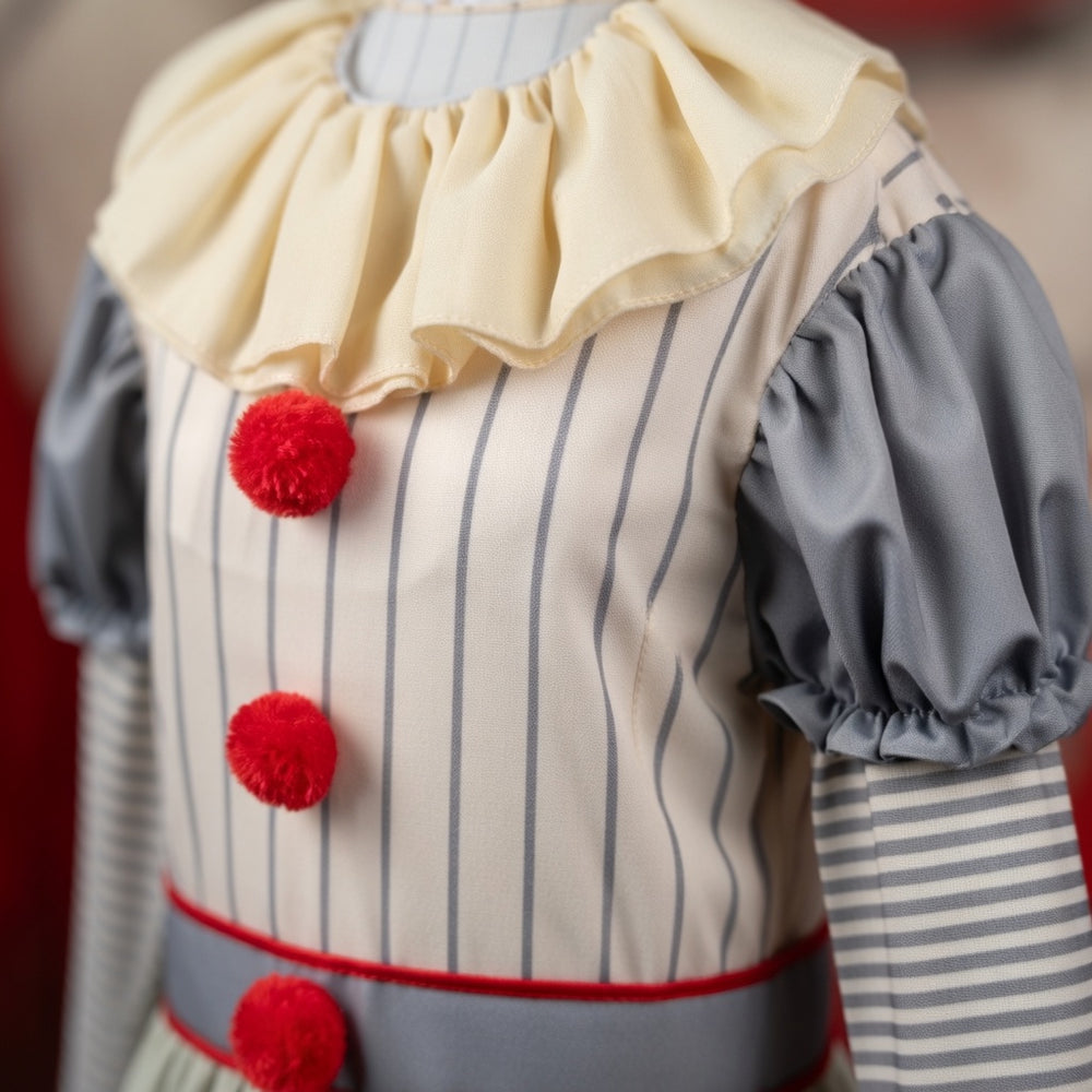 Close-up of a striped clown costume with ruffled collar, gray puff sleeves, and red pom-poms