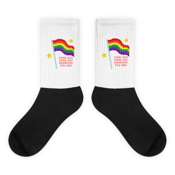 Pair of black and white crew socks with rainbow flags, stars, and “COME OUT” text