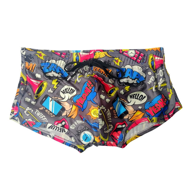 Front view of gray comic-print swim briefs with colorful speech bubbles and pop-art graphics