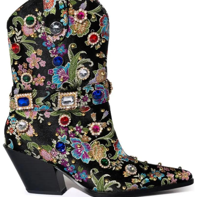 Side view of a black pointed-toe ankle boot with colorful floral embroidery and jeweled buckles