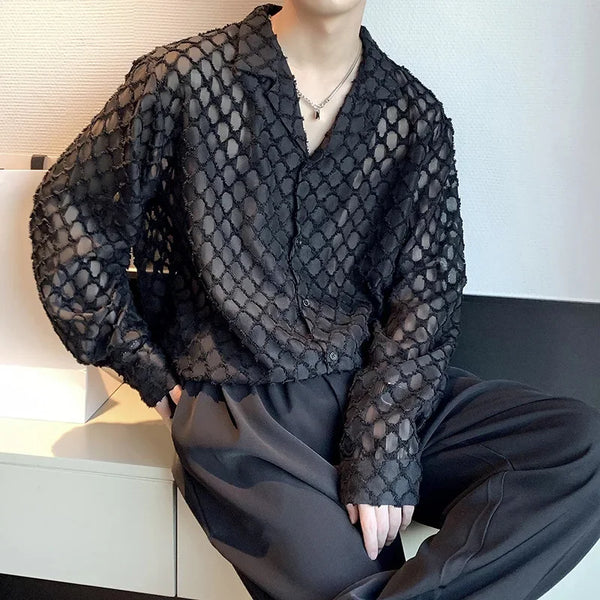Model wearing a sheer black crocheted button-front shirt with an open lattice pattern