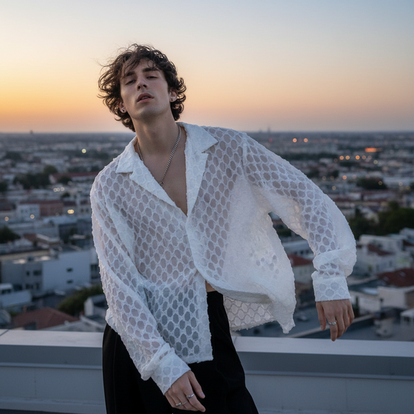 Model wearing a sheer white crochet shirt with a wide collar at sunset