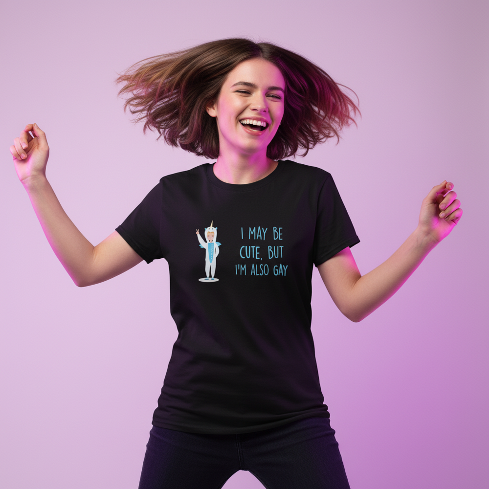 Cute But Gay T-Shirt on a smiling person with brown hair, arms raised, against a pink and purple backdrop