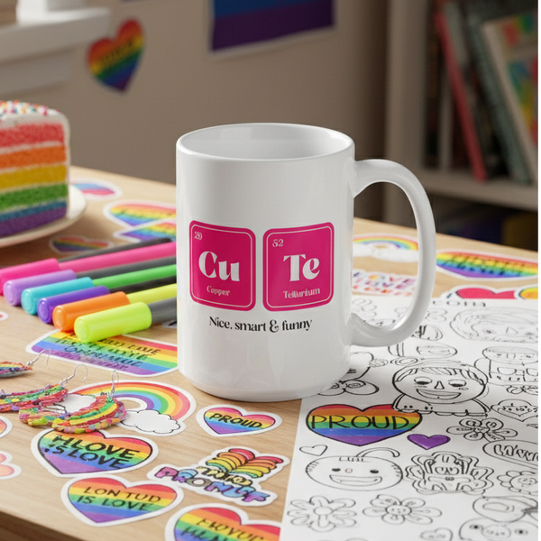 White mug labeled “Cu Te” and “Nice, smart & funny” on a pride-themed tabletop