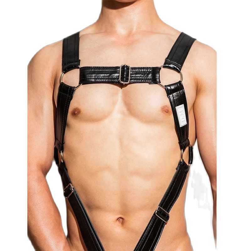 Front view of a shirtless model wearing a black leather chest harness with metal rings