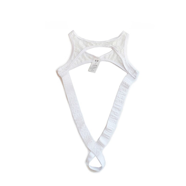 White lace thong bodysuit laid flat, with a chest cutout and crossed straps forming a bottom loop