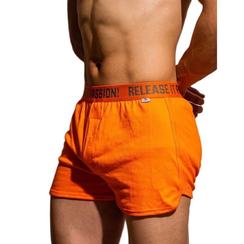 Person wearing bright orange boxer shorts, front pockets; shorts with “D.M. Release It! Comfy Boxer” design