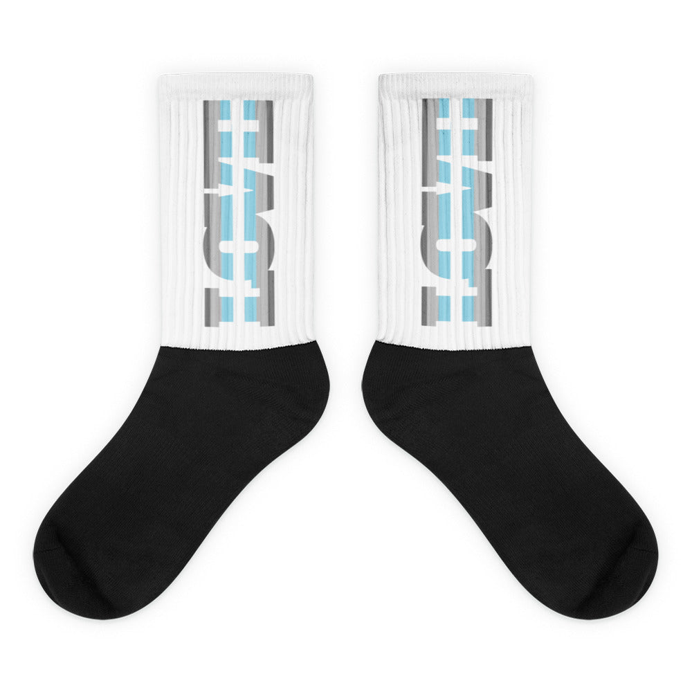 Pair of black-toe crew socks with white ribbed cuffs and blue-gray graphics