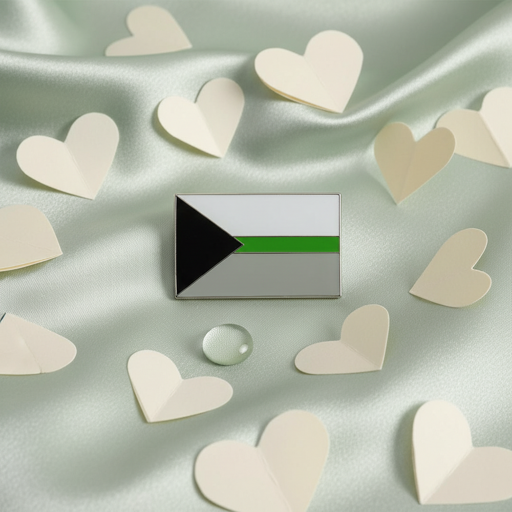 Rectangular demiromantic pride flag enamel pin on pale-green satin with paper hearts
