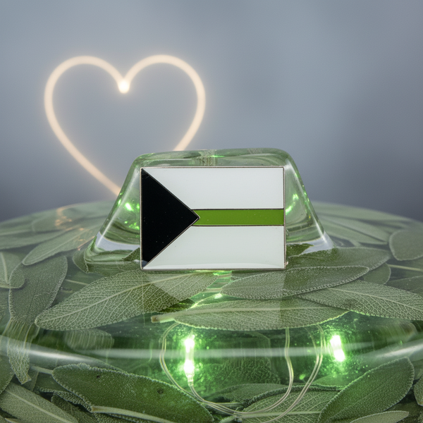 Demiromantic pride flag enamel pin displayed on a green leaf-covered glass dome