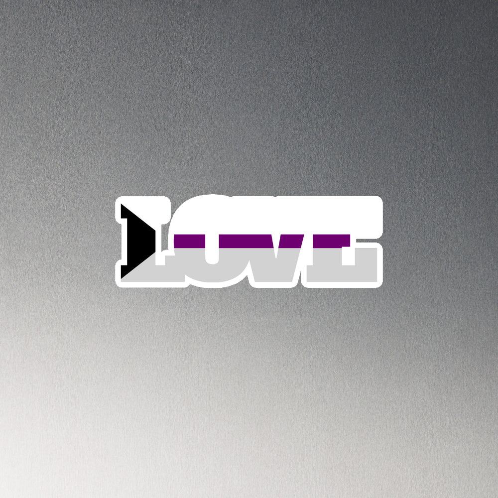 White-edged magnet spelling LOVE in gray, purple, and black on a gray background