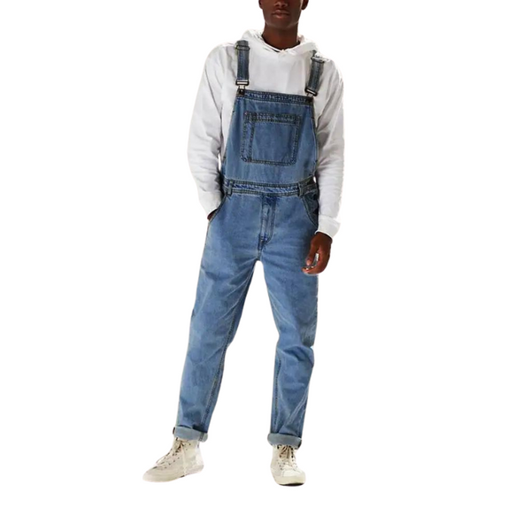 Front-view model wearing blue denim overalls over a white hooded sweatshirt