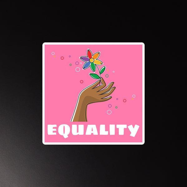 Equality magnet photographed straight on, showing a brown hand holding a multicolored flower on pink