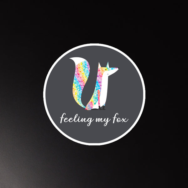 Round magnet showing a colorful fox and the words “feeling my fox”