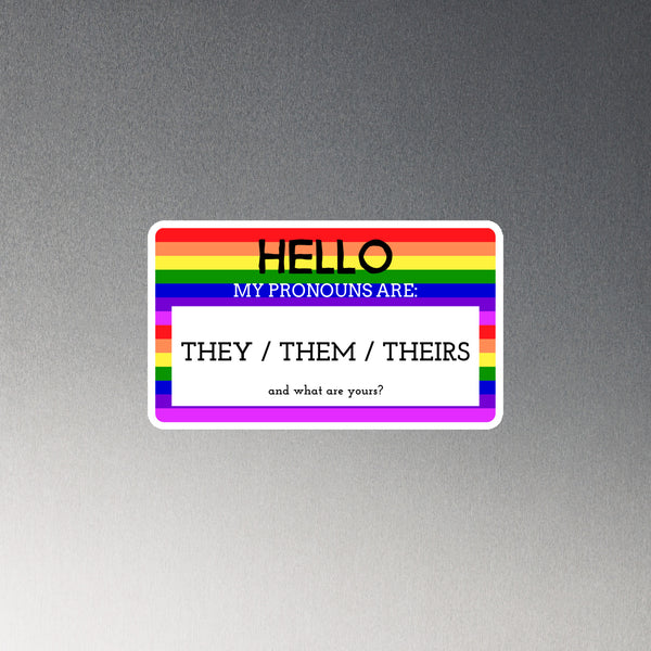 Rainbow-striped rectangular magnet reading “Hello, my pronouns are: they / them / theirs”