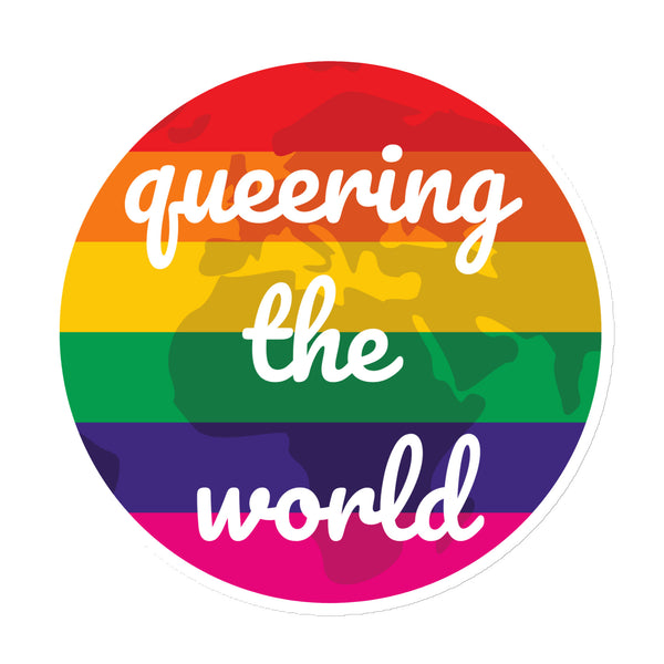 Round rainbow-striped magnet reading “queering the world” over a dark world map
