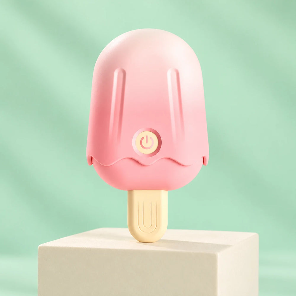 Pink ice-cream-shaped clitoris vibrator with cream handle, grooved cap and power button on a mint studio background.
