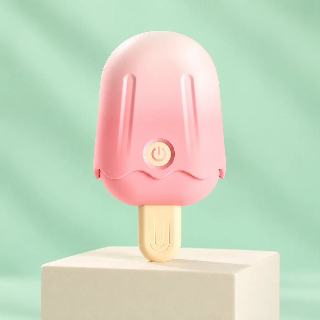 Pink ice-cream-shaped clitoris vibrator with cream handle, grooved cap and power button on a mint studio background.