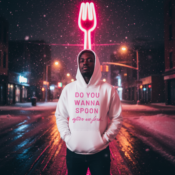 Model wearing a white hoodie reading “DO YOU WANNA SPOON after we fork...” in a snowy neon-lit street