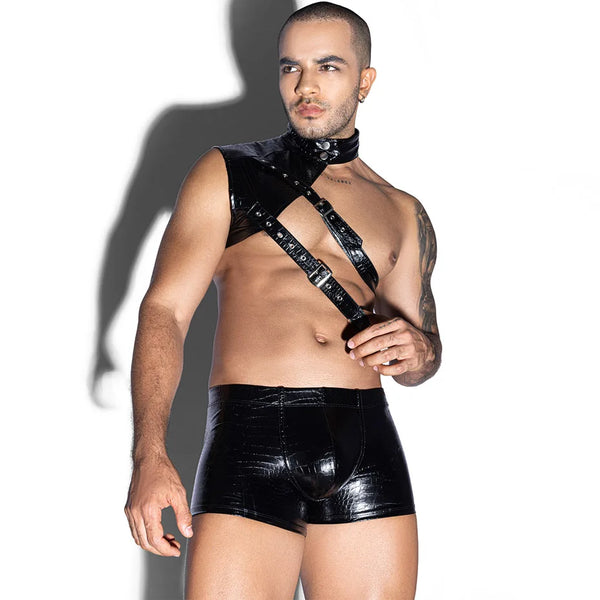 Front-facing model wearing a glossy black chest harness, collar, and fitted shorts