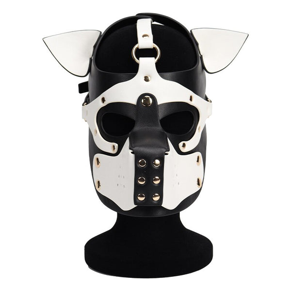 Front view of a black-and-white dog mask with pointed ears, eye openings, and metal studs