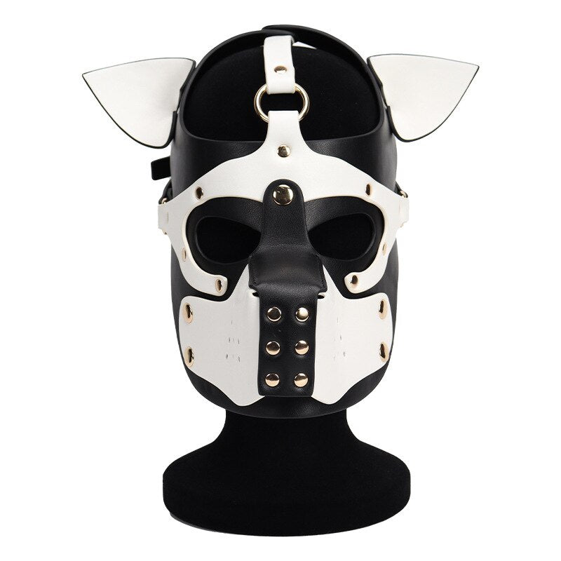 Front view of a black-and-white dog mask with pointed ears, eye openings, and metal studs