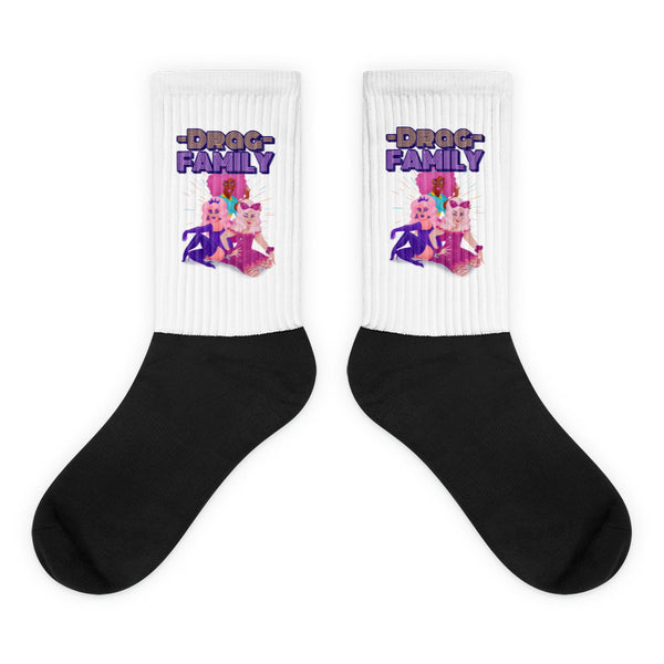 Pair of black-and-white socks with “DRAG FAMILY” text and three colorful drag performers