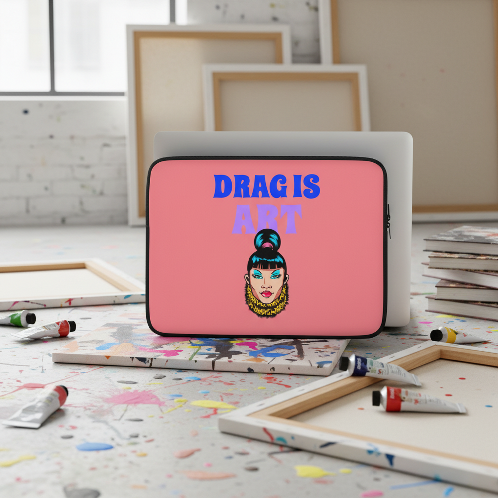 Laptop sleeve made of pink neoprene, features a drag queen face and bold “DRAG IS ART” in blue and purple