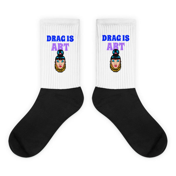 Pair of black-and-white socks with “DRAG IS ART” and drag performer portraits