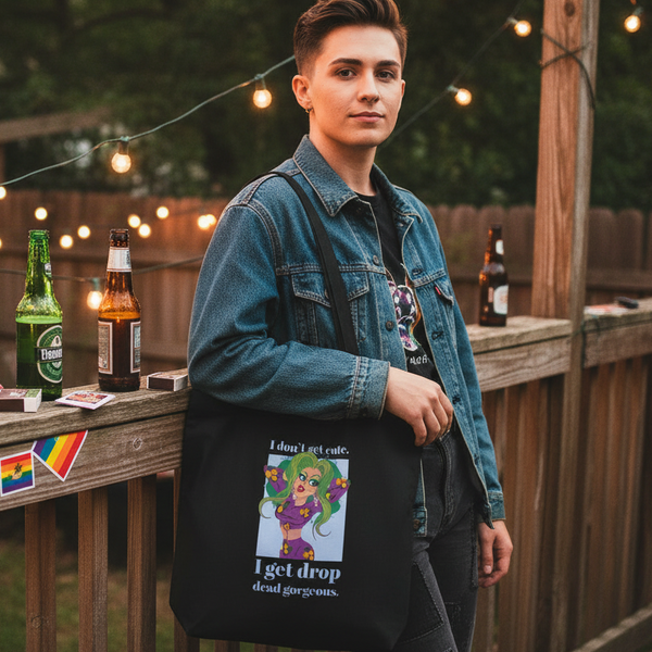 Person modeling a black tote with a colorful cartoon and “Drop Dead Gorgeous” text