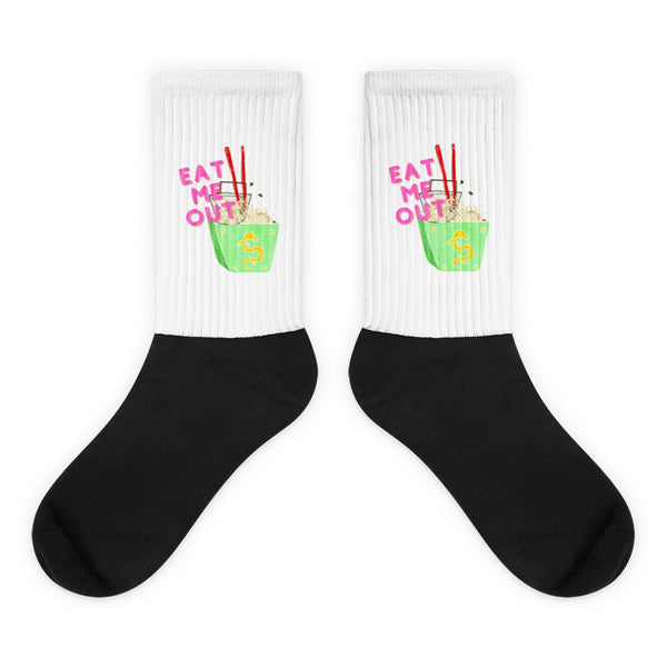 Pair of white-and-black crew socks with green noodle bowls and pink “EAT ME OUT” text