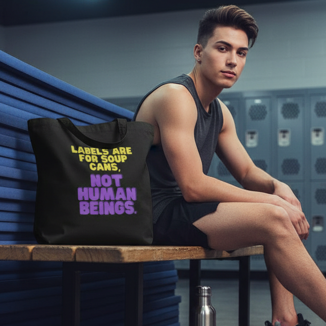 Young person in workout attire sits beside a Labels Are For Soup Cans Eco Tote Bag on a gym bench. The black tote, made from organic cotton, promotes pride and self-expression.