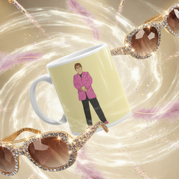 White mug with a person in a bright pink blazer, shown amid glittery sunglasses and pink feathers