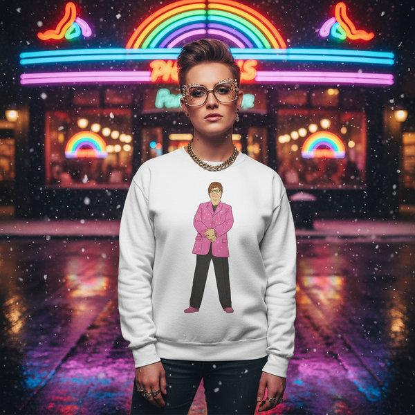 Model wearing a white sweatshirt with a cartoon figure in a pink suit, outside a neon rainbow-lit storefront