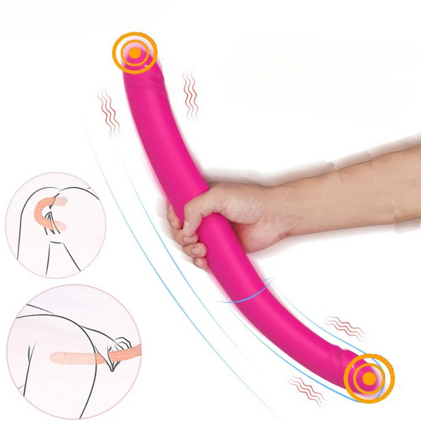 Hand holding a curved pink double-ended strapless strap-on dildo with vibrating icons