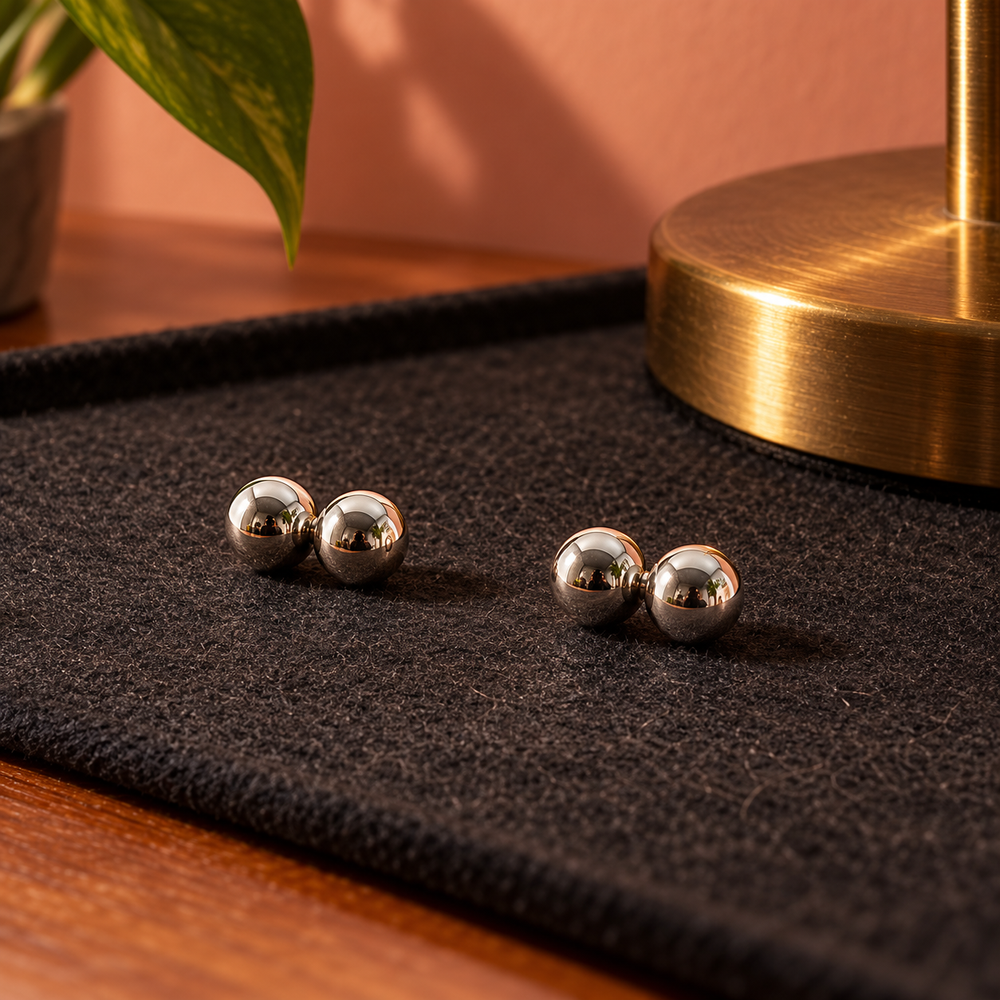 Four polished silver magnetic nipple balls displayed on a jewellery workbench.